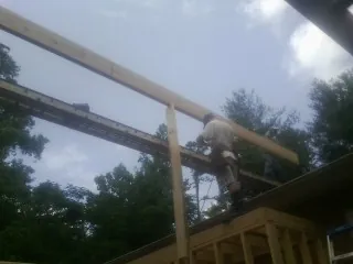Carpenter setting a ridge beam over a new addition frame — Ice Dam Removal by Roofing Brothers in Gladstone