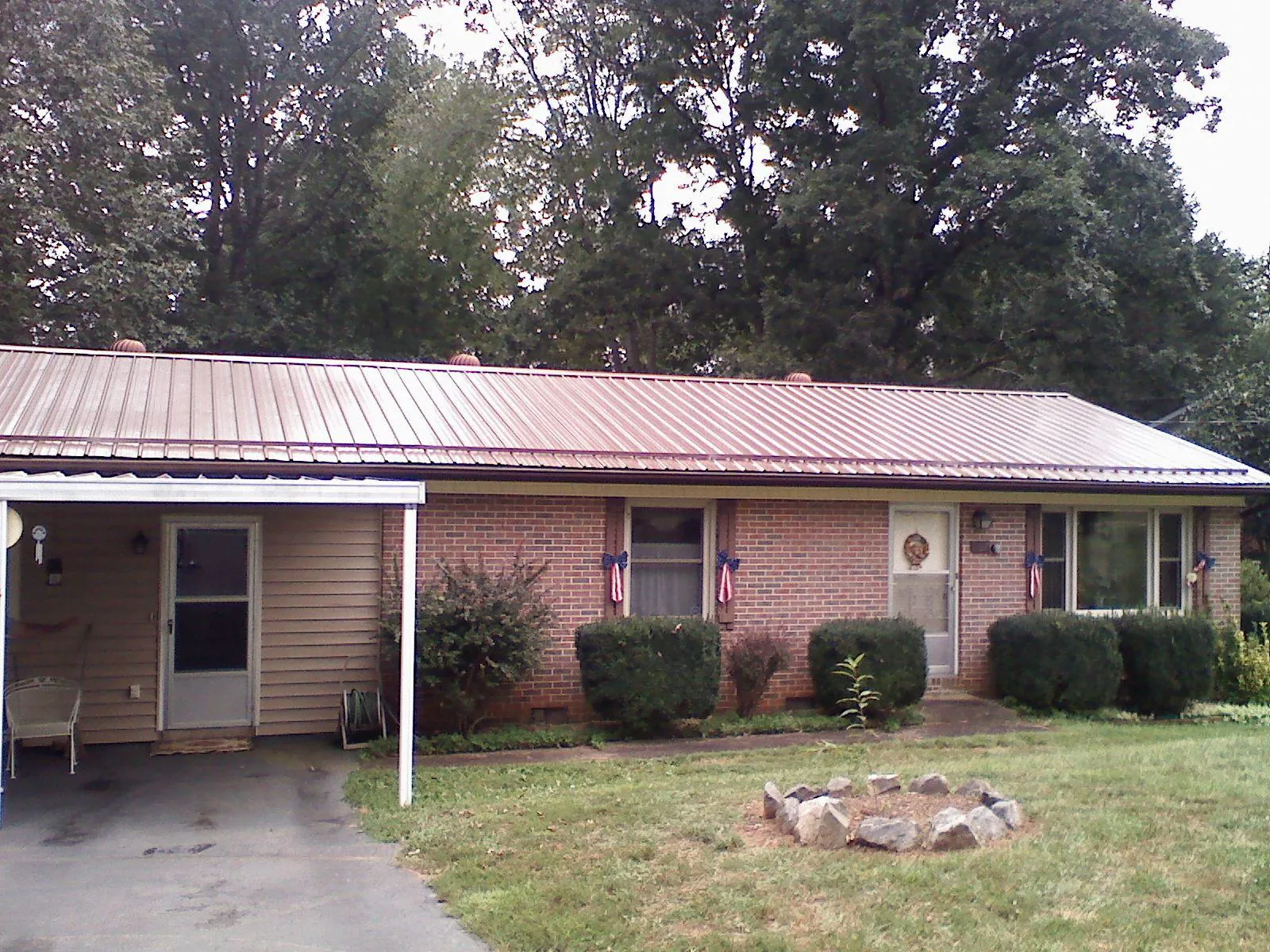 Bronze metal roof and carport on a brick ranch home — Roof Repair work by our crew in Gladstone
